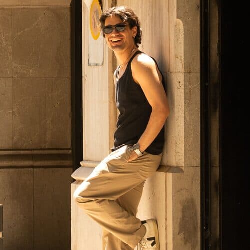 Someone leaning in a sunlit stone doorway on a Barcelona street