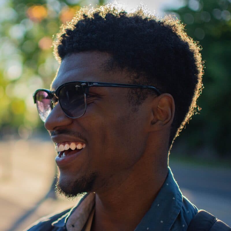 A person laughing in low afternoon sun, backlit
